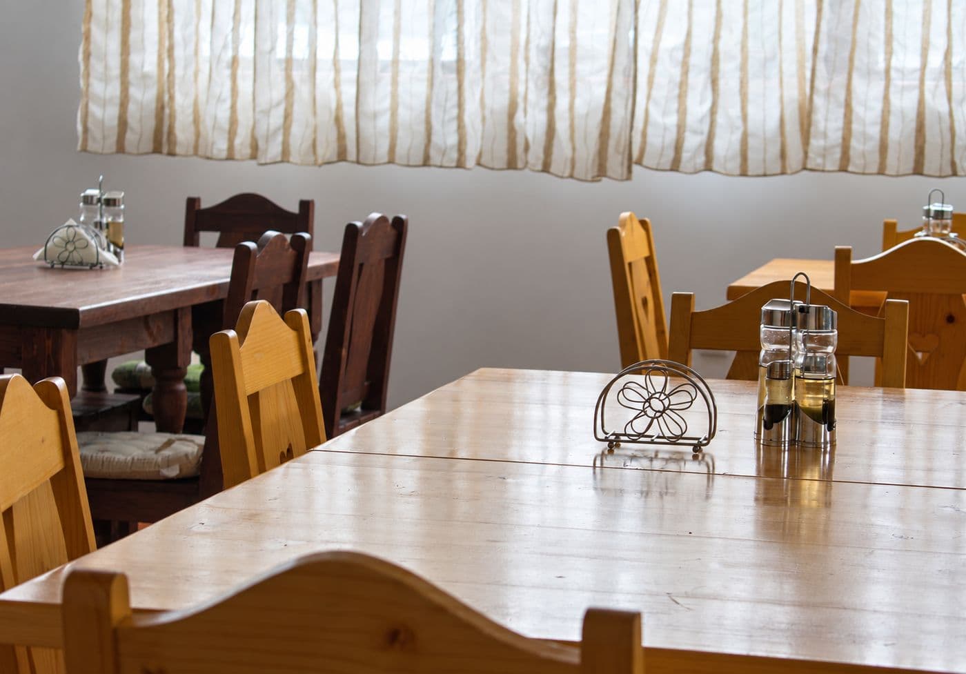 Sala de mese a pensiunii, cu mese și scaune din lemn
