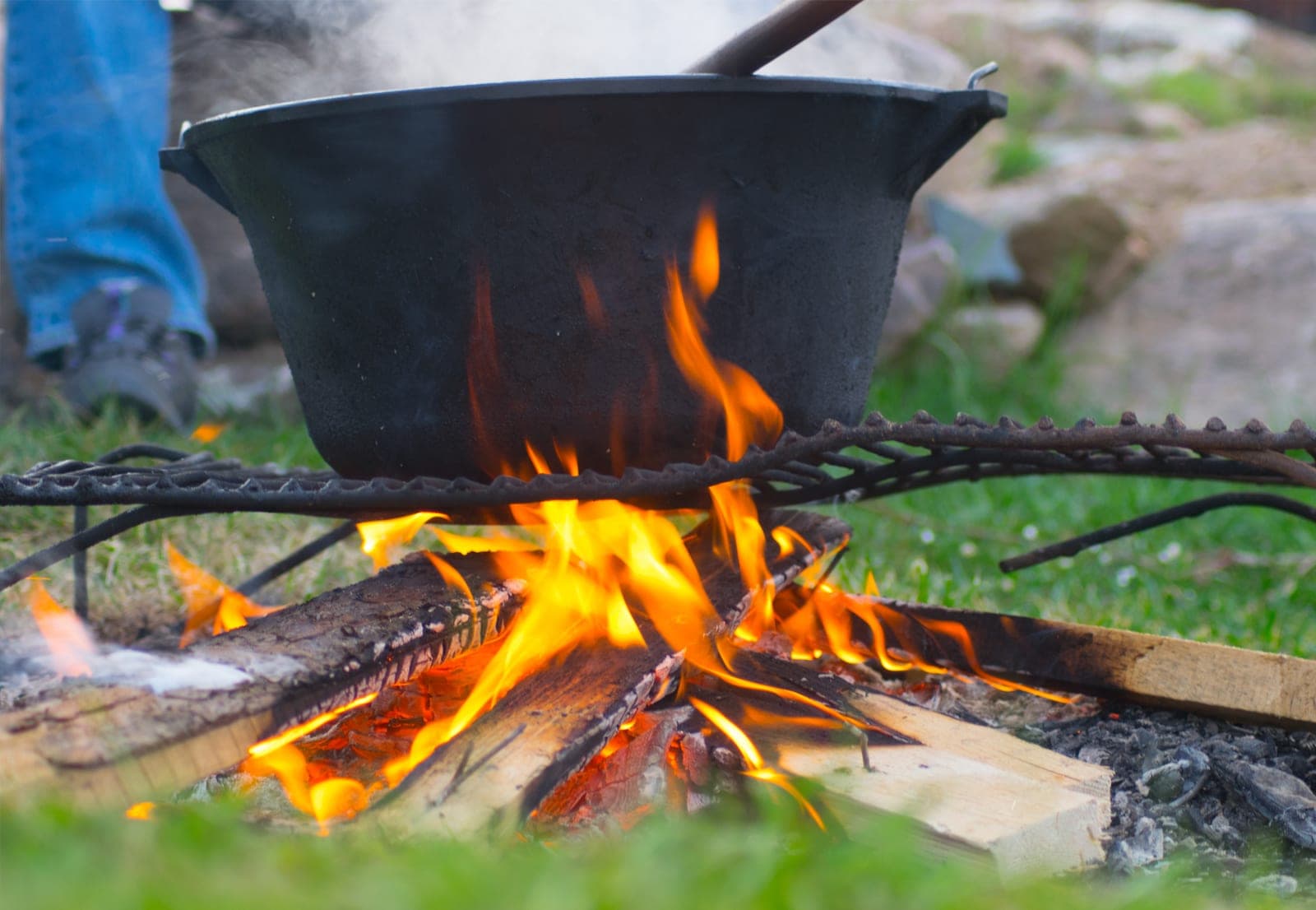 Ceaun pe foc de lemne, afară, pe iarbă